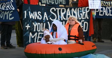 Young Christians hold a demonstration, depicting Jesus, Mary and Joseph as refugees in an inflatable dinghy boat, outside of St Paul&#039;s Cathedral in response to increasing anti-refugee politics and the growing rise of Christian nationalism in London, UK, Dec. 13, 2025. (AFP Photo)