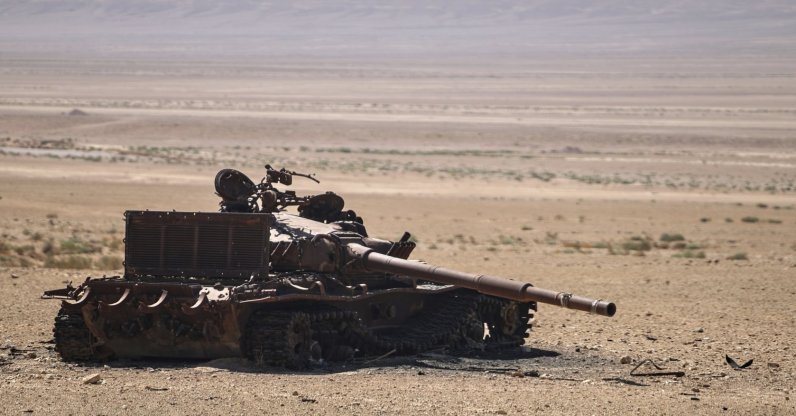 An abandoned, burned-out tank sits in the middle of a desert near the ancient city of Palmyra, Syria, Aug. 26, 2025. (AP Photo)