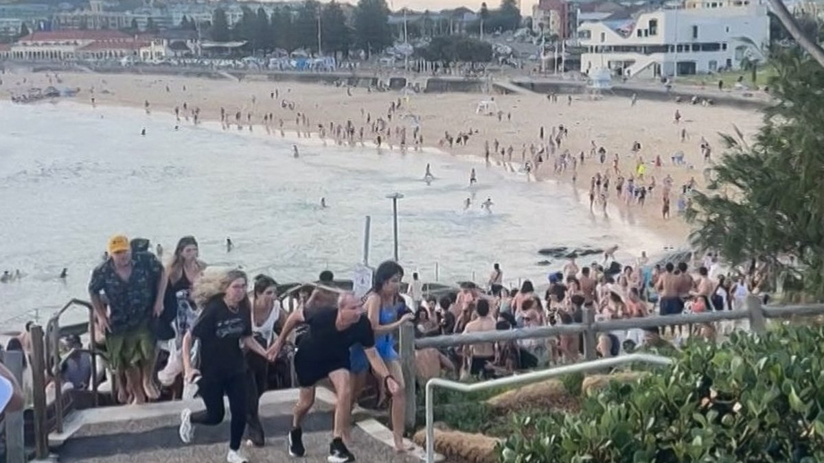 This screen grab of UGC video received courtesy of Mike Ortiz shows beach-goers fleeing Bondi Beach after gunmen opened fire, in Sydney, Australia, Dec. 14, 2025. (AFP Photo)
