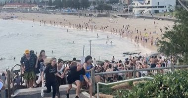 This screen grab of UGC video received courtesy of Mike Ortiz shows beach-goers fleeing Bondi Beach after gunmen opened fire, in Sydney, Australia, Dec. 14, 2025. (AFP Photo)