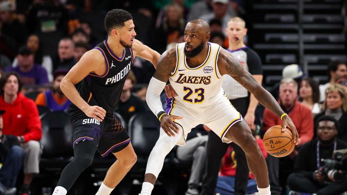Phoenix Suns' Devin Booker (L) defends Los Angeles Lakers' Lebron James during the second half of a game at Mortgage Matchup Center, Phoenix, U.S., Dec. 14, 2025. (AFP Photo)