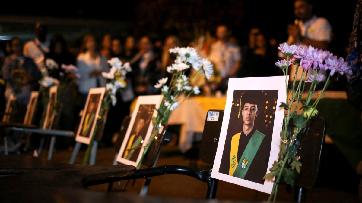 Photographs of students are displayed on school desks during a vigil for victims of a bus accident, outside the Liceo Antioqueno in Bello, Colombia, Dec. 14, 2025. (Reuters Photo)