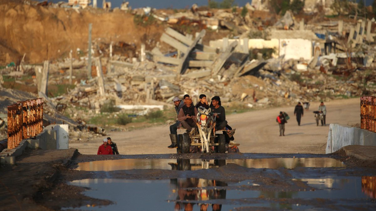 Palestinians ride a donkey cart past buildings and homes destroyed by the Israeli military, central Gaza Strip, Palestine, Dec. 13, 2025. (AFP Photo)