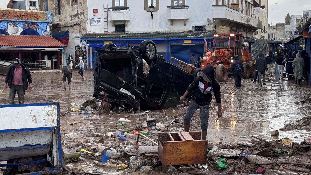 People look at a destroyed vehicle and other debris following a flash flood in the coastal town of Safi, Morocco, Dec. 15, 2025. (AFP Photo)