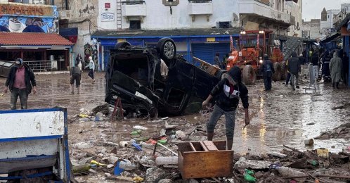 People look at a destroyed vehicle and other debris following a flash flood in the coastal town of Safi, Morocco, Dec. 15, 2025. (AFP Photo)