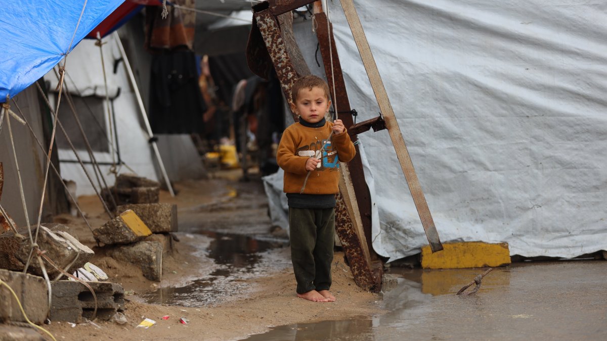 A Palestinian child stands among flooded tents at a camp for war-displaced, in al-Mawasi neighborhood, Gaza Strip, Palestine, Dec. 16, 2025. 