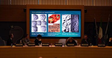 A paleontologist comments on a video reflected on a screen during a news conference presenting the discovery of thousands of dinosaur tracks in Stelvio National Park, Milan, Italy, Dec. 16, 2025. (AFP Photo)