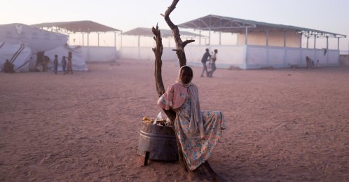 A Sudanese refugee girl from el-Fasher rests next to a burnt tree in the middle of the Tine transit camp, eastern Chad, Nov. 23, 2025. (Reuters Photo)