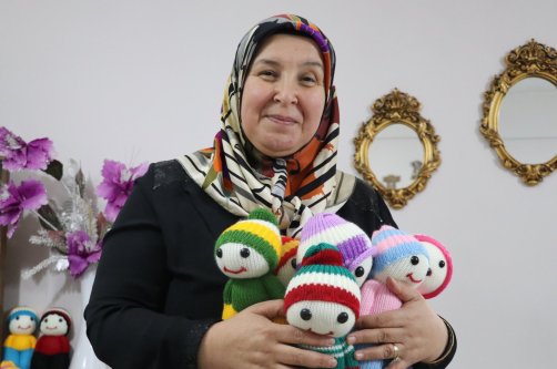 Zehra Bağcı poses with the handmade dolls she knits for children living without family support, Yozgat, Türkiye, Dec. 5, 2025. (AA Photo)