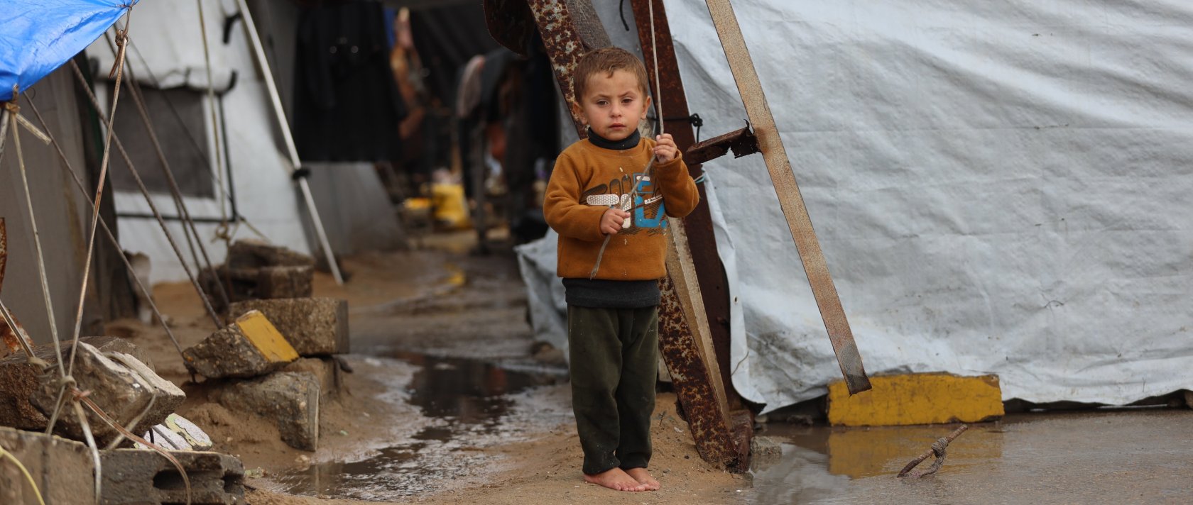 A Palestinian child stands among flooded tents at a camp for war-displaced, in al-Mawasi neighborhood, Gaza Strip, Palestine, Dec. 16, 2025. 