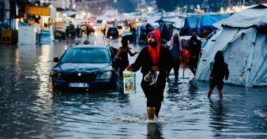 Displaced Palestinians wade through floodwaters following heavy rains in Gaza City, central Gaza Strip, Palestine, Dec. 15, 2025. (AFP Photo)