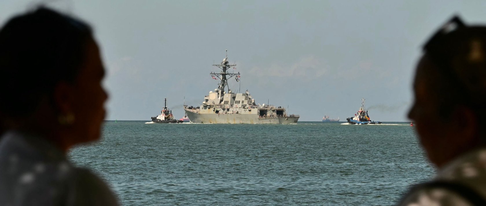 People watch the USS Gravely, a U.S. Navy warship, departing the Port of Port of Spain, Oct. 30, 2025. (AFP Photo)