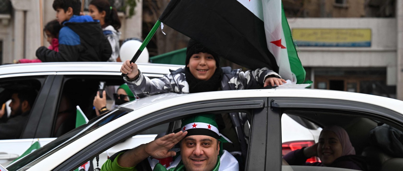 A boy waves a Syrian flag as they celebrate a year since the ousting of longtime ruler Bashar Assad in the capital Damascus, Syria, Dec. 8, 2025. (AFP Photo)