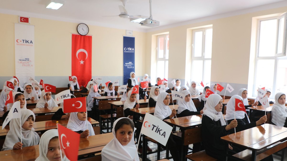 Students hold TIKA and Türkiye flags inside a classroom at the newly opened school in Moghlan village, Takhar province, Afghanistan, Dec. 10, 2025. (AA Photo)