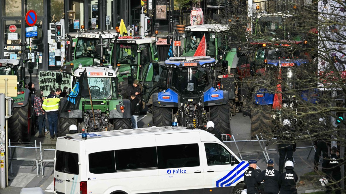 Police officers stand in front of tractors parked in line near the European Parliament, during a farmers' protest to denounce the reforms of the Common Agricultural Policy (CAP) and trade agreements such as the Mercosur, in Brussels, Belgium, Dec. 18, 2025. (AFP Photo)