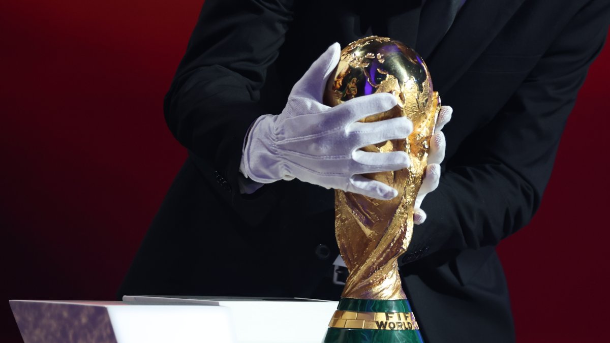 Argentina's head coach Lionel Scaloni places the FIFA World Cup trophy during the draw for the 2026 World Cup at the Kennedy Center, Washington, U.S., Dec. 5, 2025. (AP Photo)