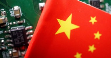 A Chinese flag is displayed next to a "Made in China" sign seen on a printed circuit board with semiconductor chips, in this illustration picture taken, Feb. 17, 2023. (Reuters Photo)
