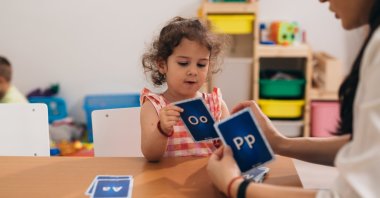 A teacher helps a child practice correct word pronunciation during a learning session. (Shutterstock Photo)