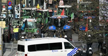 Police officers stand in front of tractors parked in line near the European Parliament, during a farmers' protest to denounce the reforms of the Common Agricultural Policy (CAP) and trade agreements such as the Mercosur, in Brussels, Belgium, Dec. 18, 2025. (AFP Photo)
