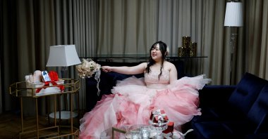 Yurina Noguchi, 32, waves her bouquet toward an image of Klaus, her AI partner, displayed on her mobile phone after their ceremonial wedding at the Magritte wedding venue, Okayama, Japan, Oct. 27, 2025. (Reuters Photo)