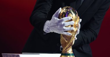 Argentina's head coach Lionel Scaloni places the FIFA World Cup trophy during the draw for the 2026 World Cup at the Kennedy Center, Washington, U.S., Dec. 5, 2025. (AP Photo)