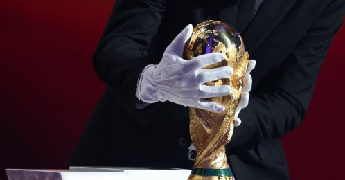 Argentina's head coach Lionel Scaloni places the FIFA World Cup trophy during the draw for the 2026 World Cup at the Kennedy Center, Washington, U.S., Dec. 5, 2025. (AP Photo)
