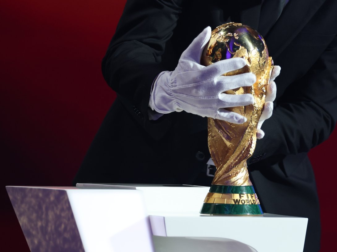 Argentina's head coach Lionel Scaloni places the FIFA World Cup trophy during the draw for the 2026 World Cup at the Kennedy Center, Washington, U.S., Dec. 5, 2025. (AP Photo)
