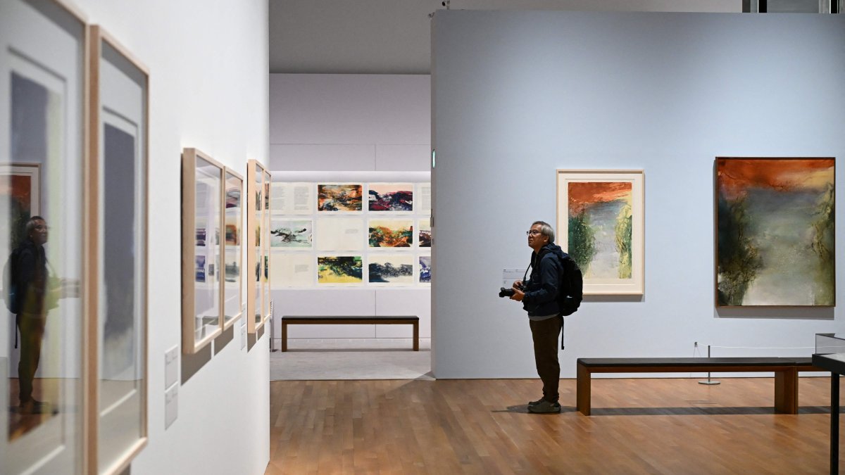 A photographer takes photos at a media preview of M  art museum's special exhibition titled "Zao Wou-Ki: Master Printmaker," the works of Chinese French artist Zao Wou-Ki (1920-2013), one of the most influential abstract artists of the mid- and late 20th century, Hong Kong, China, Dec. 11, 2025. (AFP Photo)