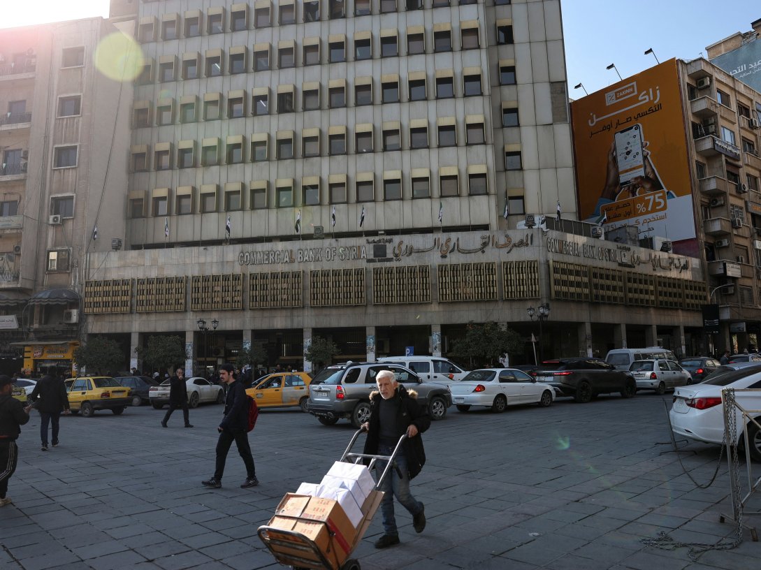A man walks past the Commercial Bank of Syria, after the National Defense Authorization Act (NDAA) repealed the tough "Caesar" sanctions imposed on Syria under its former leader Bashar Assad, in Damascus, Syria, Dec. 18, 2025. (Reuters Photo)