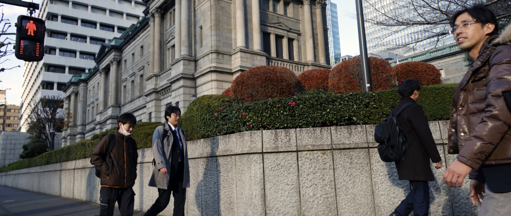 Passersby walk past the Bank of Japan (BOJ) headquarters in Tokyo, Japan, Dec. 19, 2025. (EPA Photo)