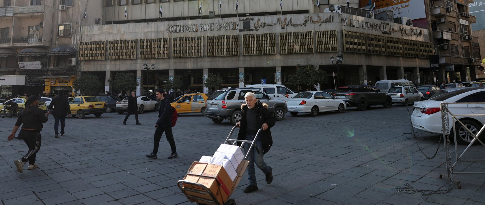 A man walks past the Commercial Bank of Syria, after the National Defense Authorization Act (NDAA) repealed the tough "Caesar" sanctions imposed on Syria under its former leader Bashar Assad, in Damascus, Syria, Dec. 18, 2025. (Reuters Photo)