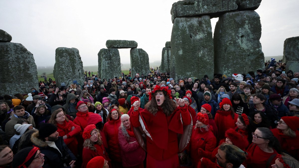 A choir performs as revelers attend winter solstice celebrations during sunrise at Stonehenge stone circle near Amesbury, Britain, Dec. 21, 2025. (Reuters Photo)