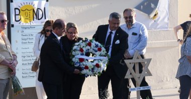 Officials from the Turkish Australian community lay a wreath as mourners gather in front of tributes in memory of victims of a shooting at Bondi Beach, Sydney, Australia, Dec. 20, 2025. (AFP Photo)
