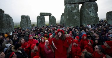 A choir performs as revelers attend winter solstice celebrations during sunrise at Stonehenge stone circle near Amesbury, Britain, Dec. 21, 2025. (Reuters Photo)