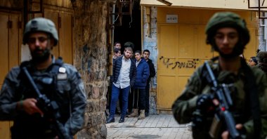 Israelis look at troops standing guard during a weekly settlers' tour in Hebron, in the Israeli-occupied West Bank, Dec. 13, 2025. (Reuters Photo)