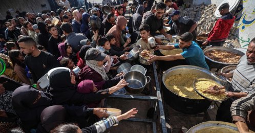 Displaced Palestinians gather to receive food portions at a charity kitchen in the Nuseirat refugee camp, central Gaza Strip, Palestine, Dec. 20, 2025. (AFP Photo)