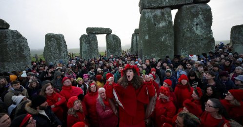 A choir performs as revelers attend winter solstice celebrations during sunrise at Stonehenge stone circle near Amesbury, Britain, Dec. 21, 2025. (Reuters Photo)