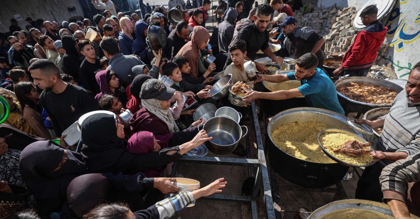 Displaced Palestinians gather to receive food portions at a charity kitchen in the Nuseirat refugee camp, central Gaza Strip, Palestine, Dec. 20, 2025. (AFP Photo)