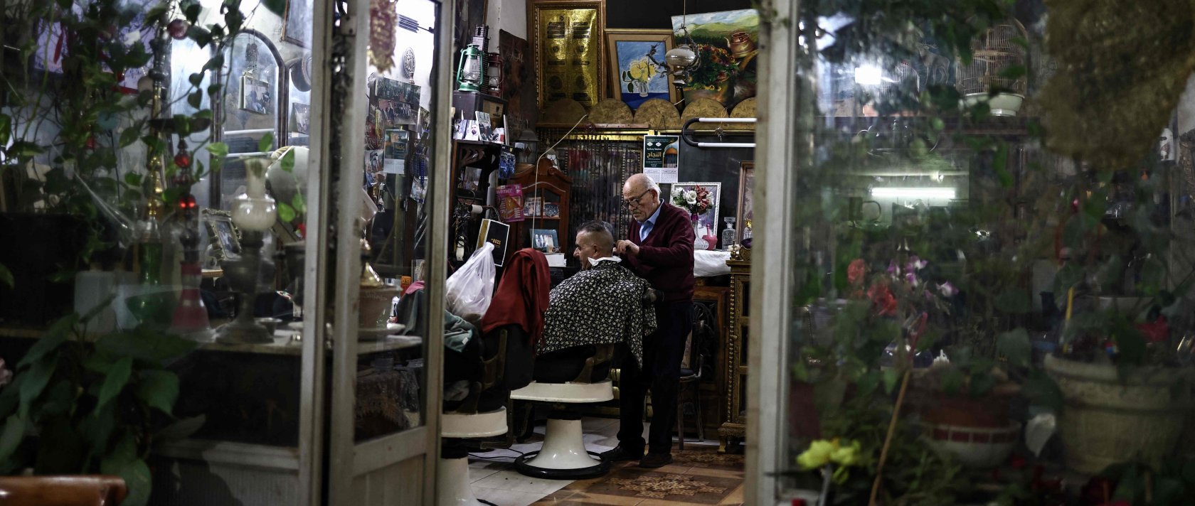 A Palestinian barber tends to a client in the old city of Nablus in the occupied West Bank, Dec. 20, 2025. (AFP Photo)