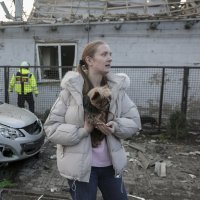 A woman holds her dog near the site of a Russian strike on a home in Zaporizhzhia, southeastern Ukraine, Dec. 19, 2025. (EPA Photo)