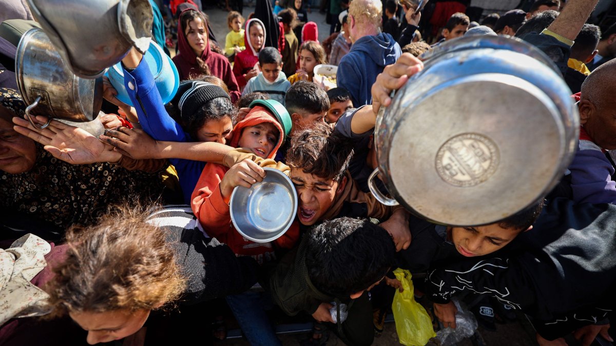 A boy reacts as displaced Palestinians gather to receive food portions at a charity kitchen in the Nuseirat refugee camp in the central Gaza Strip, Dec. 20, 2025. (AFP Photo)