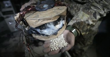 A Syrian member of the anti-regime alliance shows amphetamine pills known as Captagon hidden inside an electrical component at a warehouse, in Douma city, outskirts of Damascus, Syria, Dec. 13, 2024. (AP Photo)