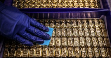 A worker polishes gold bullion bars at the ABC Refinery, Sydney, Australia, Aug. 5, 2020. (AFP Photo)