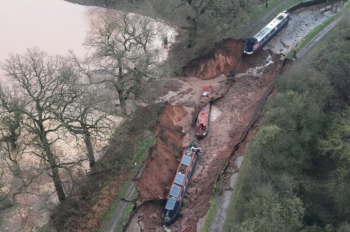 This handout aerial photo taken and released by the Shropshire Fire and Rescue Service shows boats on the bed of the canal after a sinkhole developed along the Shropshire Union Canal, draining the water, in the Chemistry area of Whitchurch, Shropshire, central England, Dec. 22, 2025. (AFP Photo)