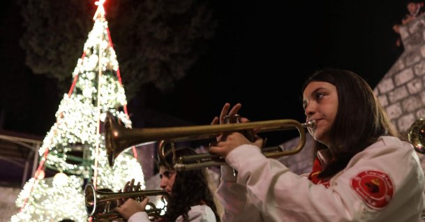 A scout's band plays as residents gather near a lit Christmas tree as they prepare for the upcoming Christmas festivities in the mainly Christian village of al-Qanayyah, Idlib, Syria, Dec. 20, 2025. (AFP Photo)