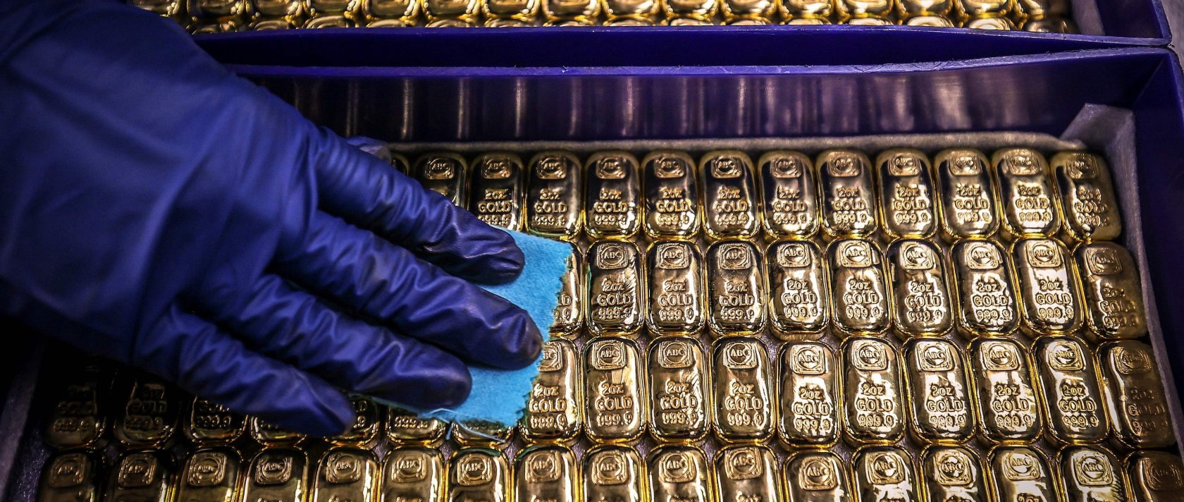 A worker polishes gold bullion bars at the ABC Refinery, Sydney, Australia, Aug. 5, 2020. (AFP Photo)