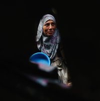 A displaced Palestinian woman waits with her container to receive donated food portions at a charity kitchen in Khan Yunis in the southern Gaza Strip, Palestine, Dec. 17, 2025. (AFP Photo)