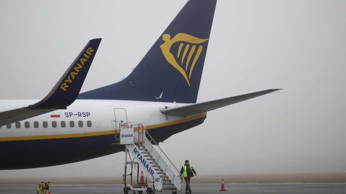 A ground handling worker walks past a Ryanair Boeing 737-8AS aircraft at Warsaw-Modlin Airport, Modlin, Poland, Dec. 1, 2025.  (Reuters Photo)