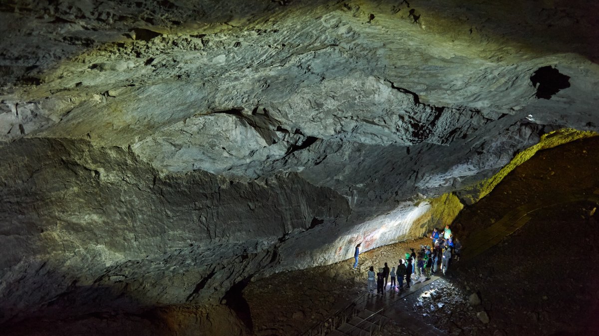 Visitors explore prehistoric rock paintings in Shulgan-Tash Cave, Bashkortostan, Russia. (Shutterstock Photo)
