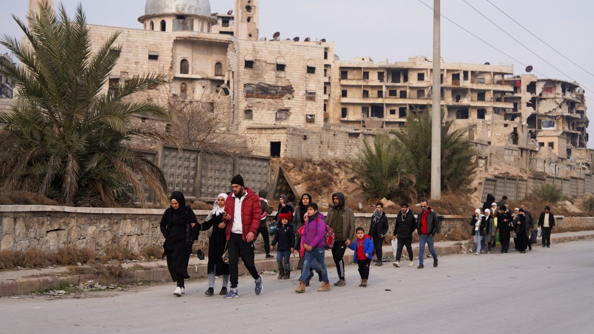 People walk together along a street after YPG/PKK shelling in Aleppo, Dec. 23, 2025. (Reuters Photo)